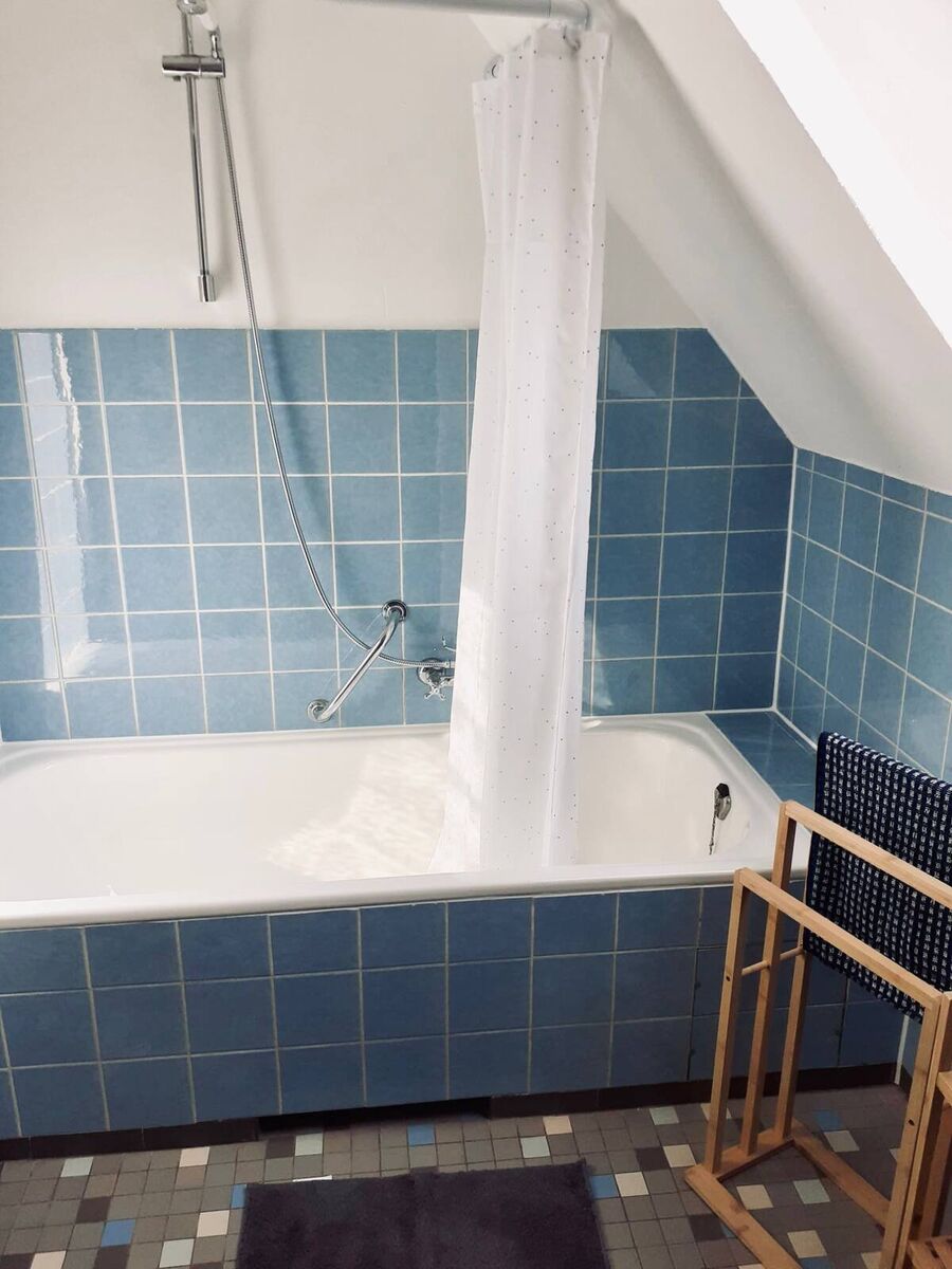 Badezimmer mit Badewanne – Haus Wiesenblick Badezimmer mit Badewanne und Dusche, blaue Fliesen, unter Dachschräge im Haus Wiesenblick