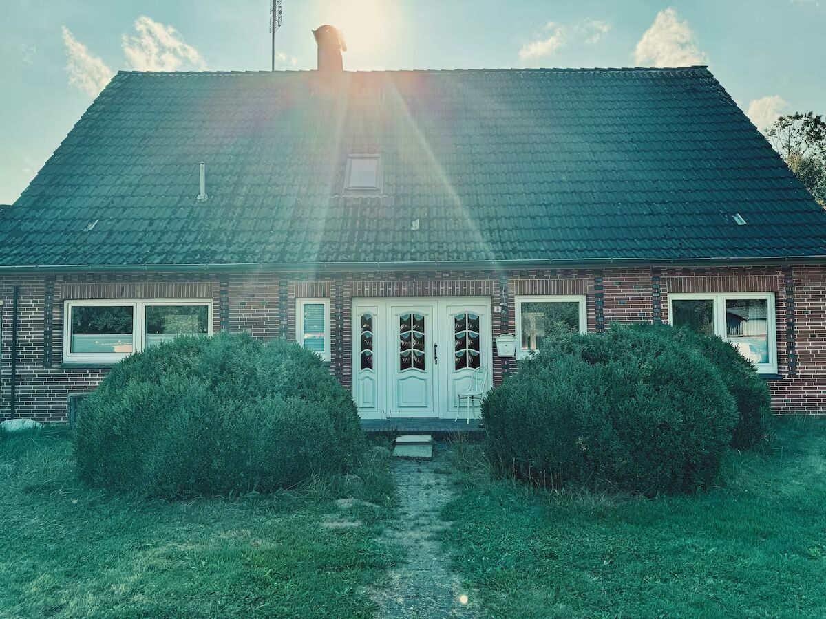 Haus Wiesenblick Vaale – Außenansicht Norddeutsches Backsteinhaus mit weißer Eingangstür – Ferienwohnung Haus Wiesenblick in Vaale