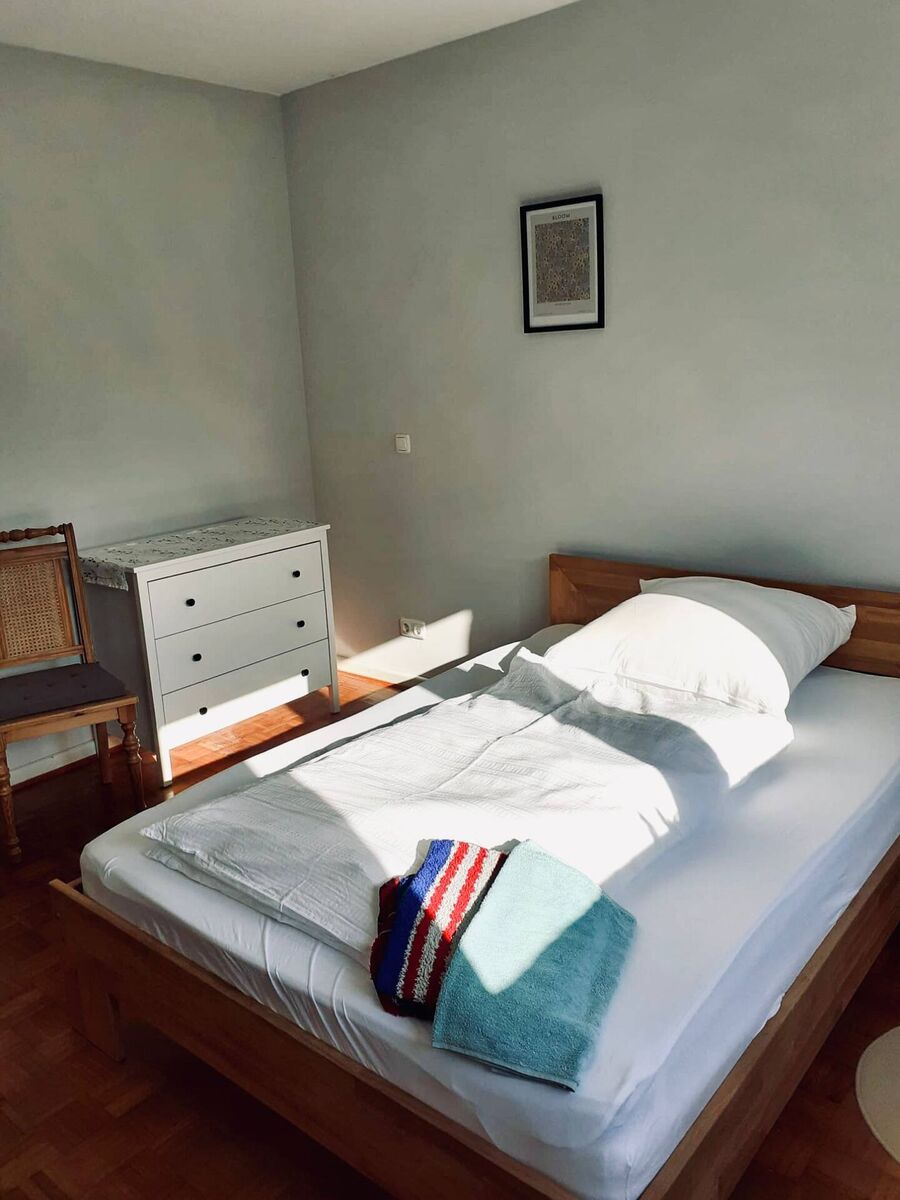 Schlafzimmer 1 – Übersicht mit Stuhl und Kommode Schlafzimmer mit Doppelbett, weißer Kommode und Holzstuhl in der Ferienwohnung Vaale
