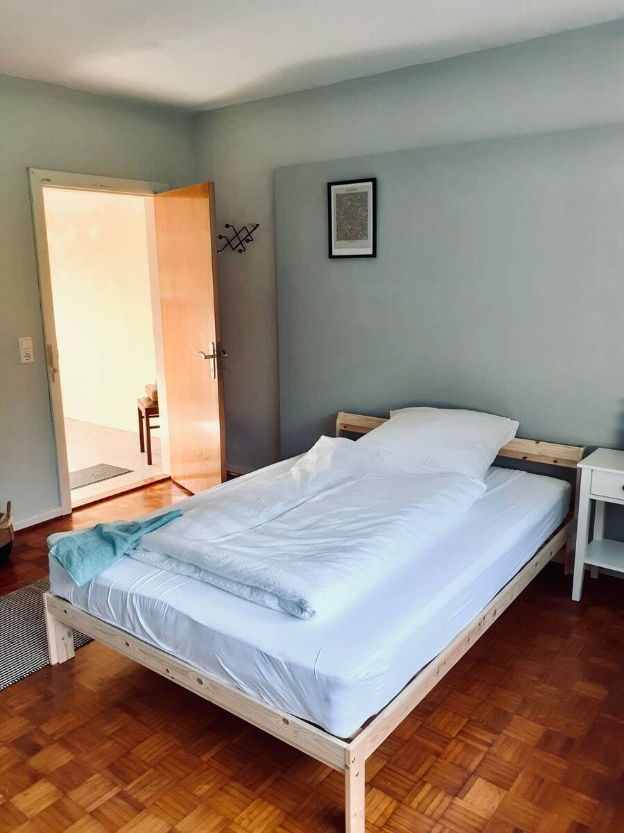 Schlafzimmer – Doppelbett mit Parkettboden Helles Schlafzimmer mit Doppelbett, Nachttisch und Parkettboden in der Ferienwohnung Vaale